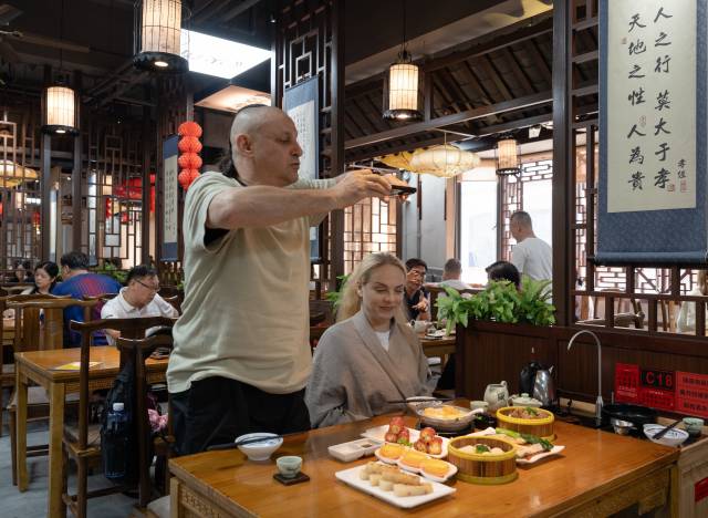 来自异国的&ldquo;新&rdquo;广州人亚诺士夫妇在越秀区叹早茶，他们对中国茶艺和糕点十分感兴趣。南方+记者 金镝 摄