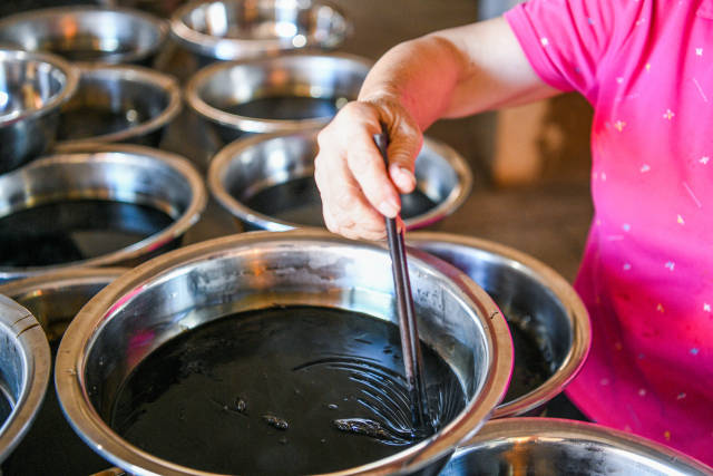 经过冷却后的仙人粄呈黑色凝胶状，食用时用小刀捣碎，配上蜂蜜和香蕉露。南方+ 记者 何森垚 摄